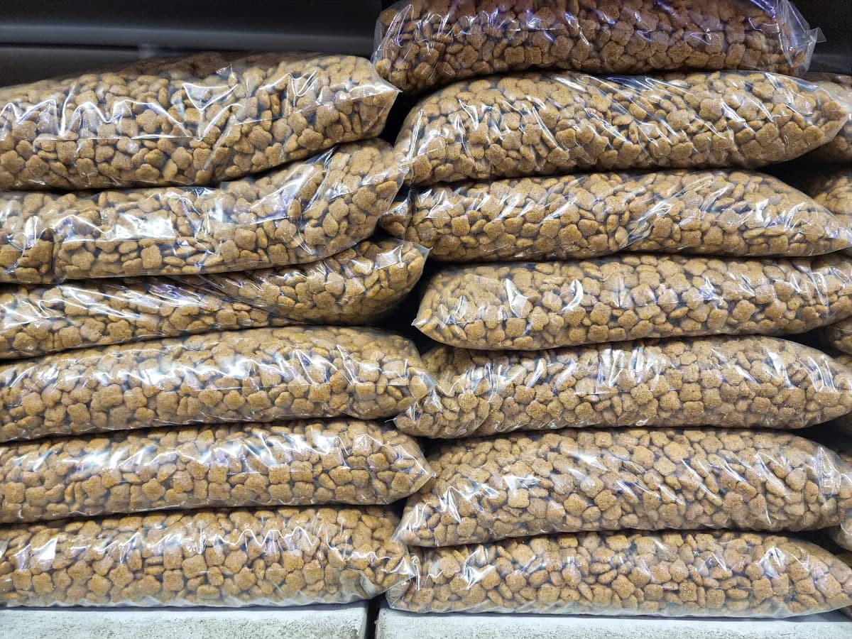 Clear bulk bags of dry pet food stacked in rows.