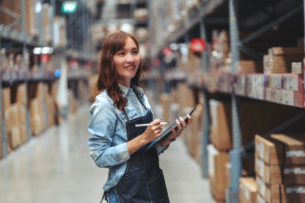 Image of a lady taking inventory numbers inside a warehouse